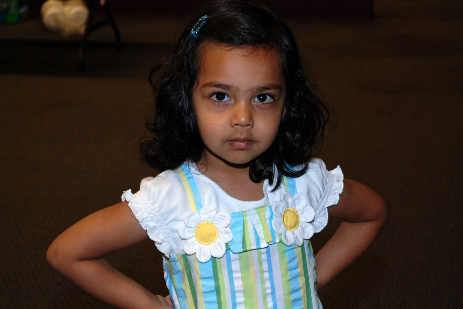 A young girl in a floral dress in the audience
