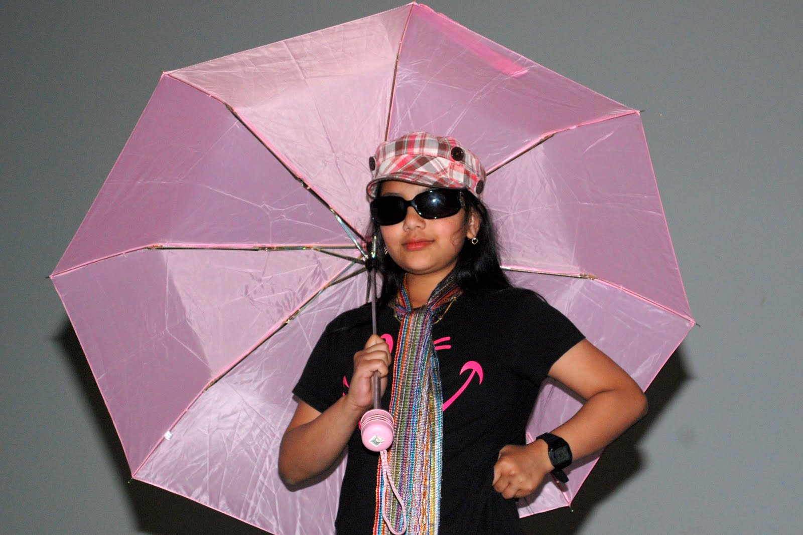 A performer in costume with a pink umbrella
