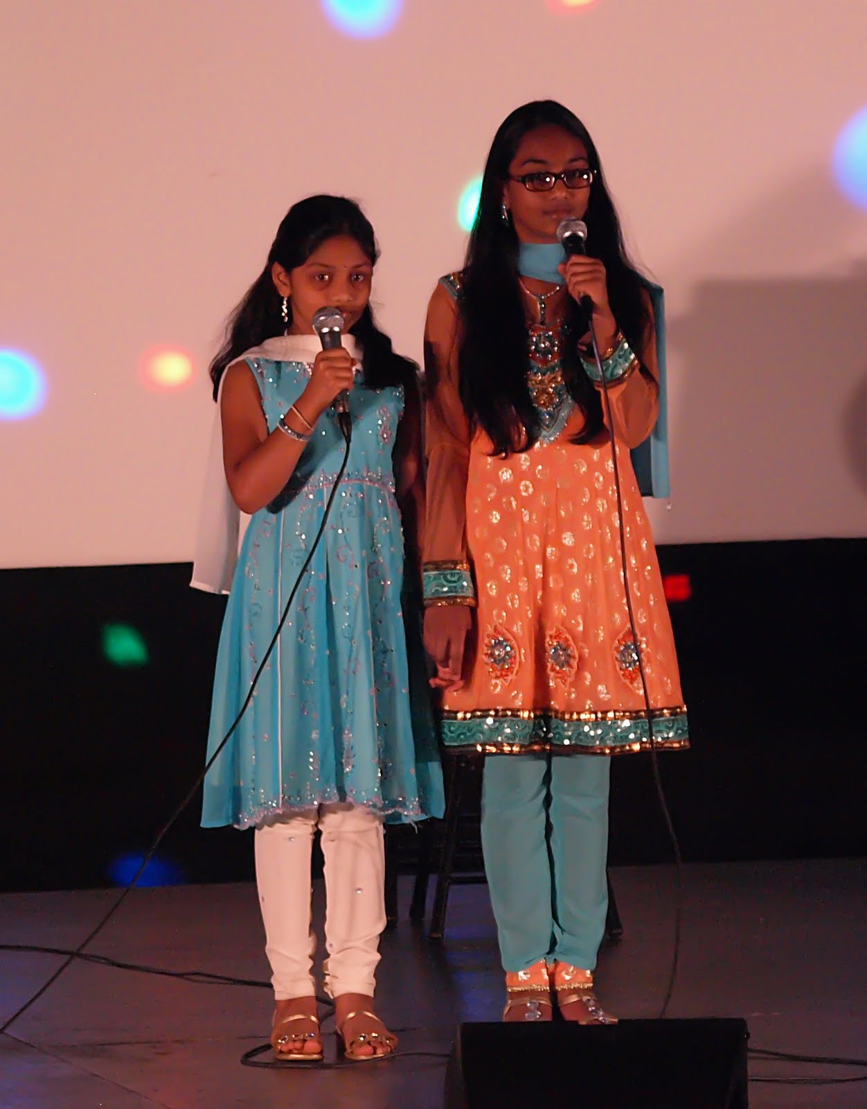 Two young girls singing together