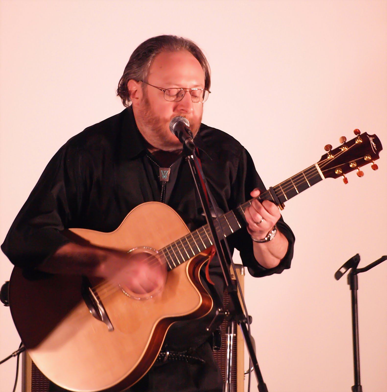 A guitarist singing and playing acoustic guitar