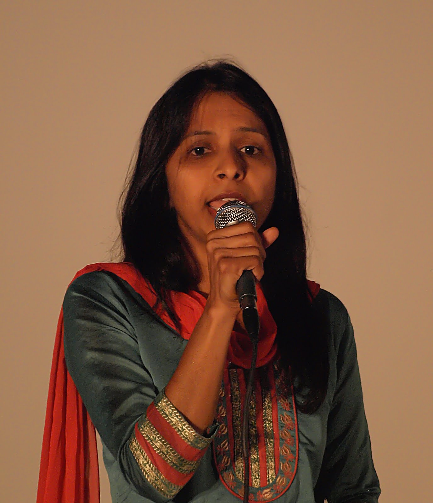 A woman in a red and green outfit, singing
