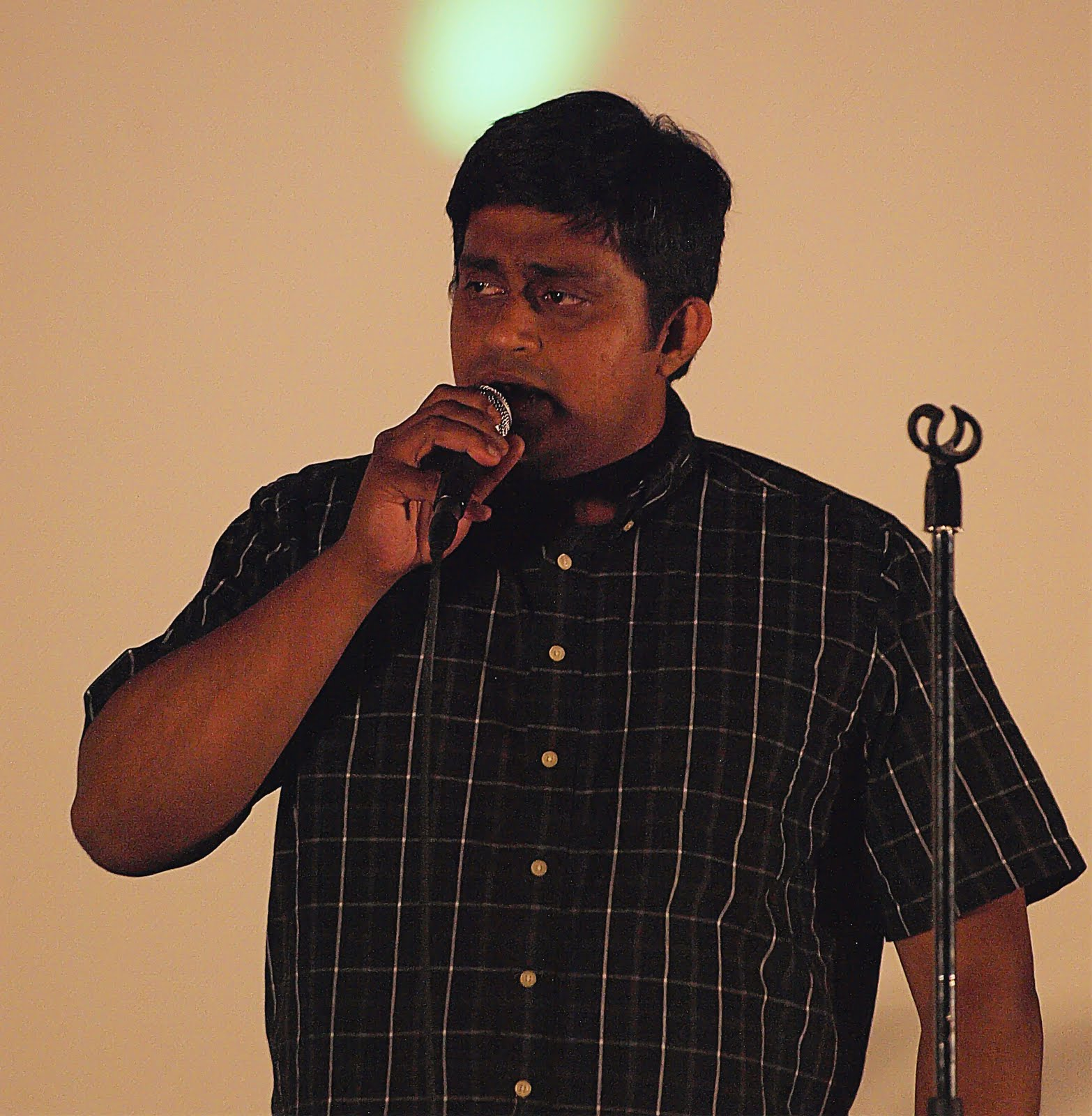A man in a checked shirt, singing