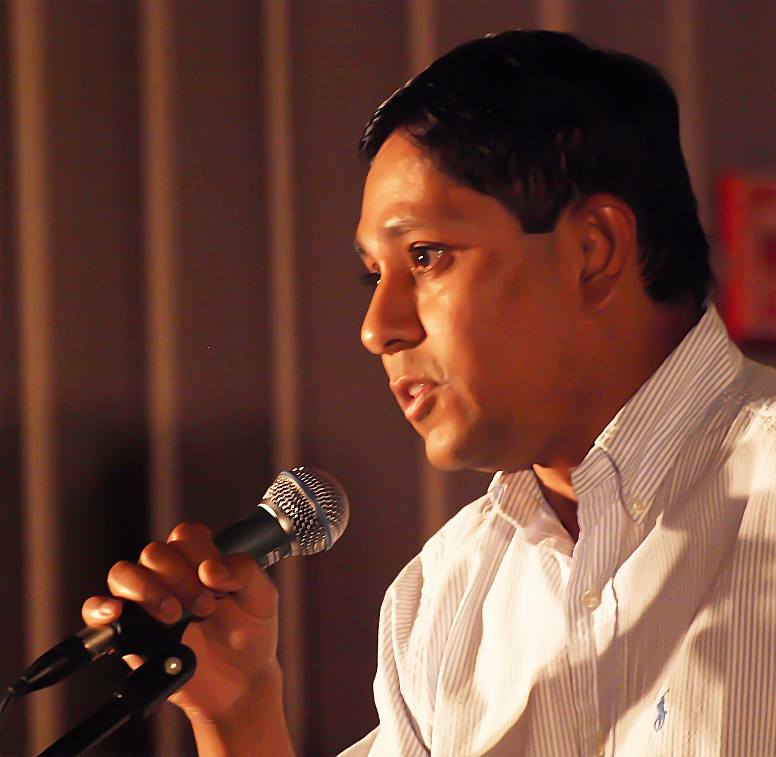 A man singing energetically into the microphone