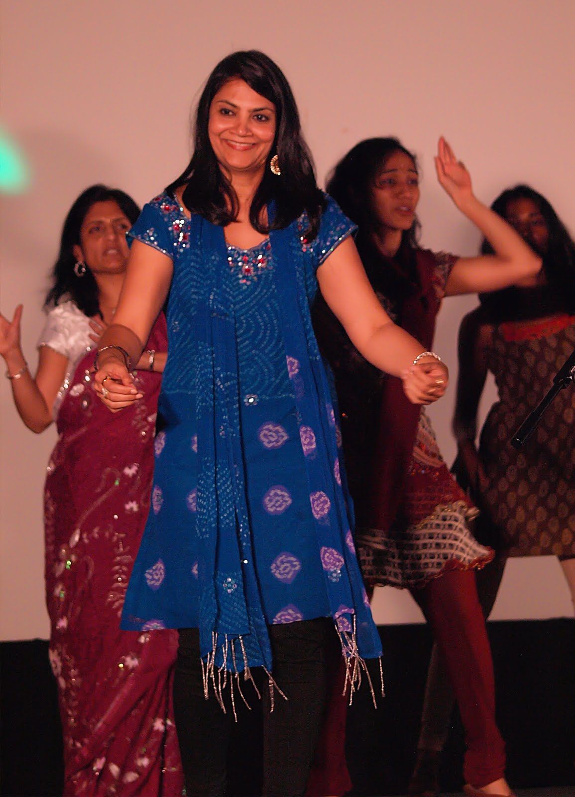 A group of women and a young girl dancing together