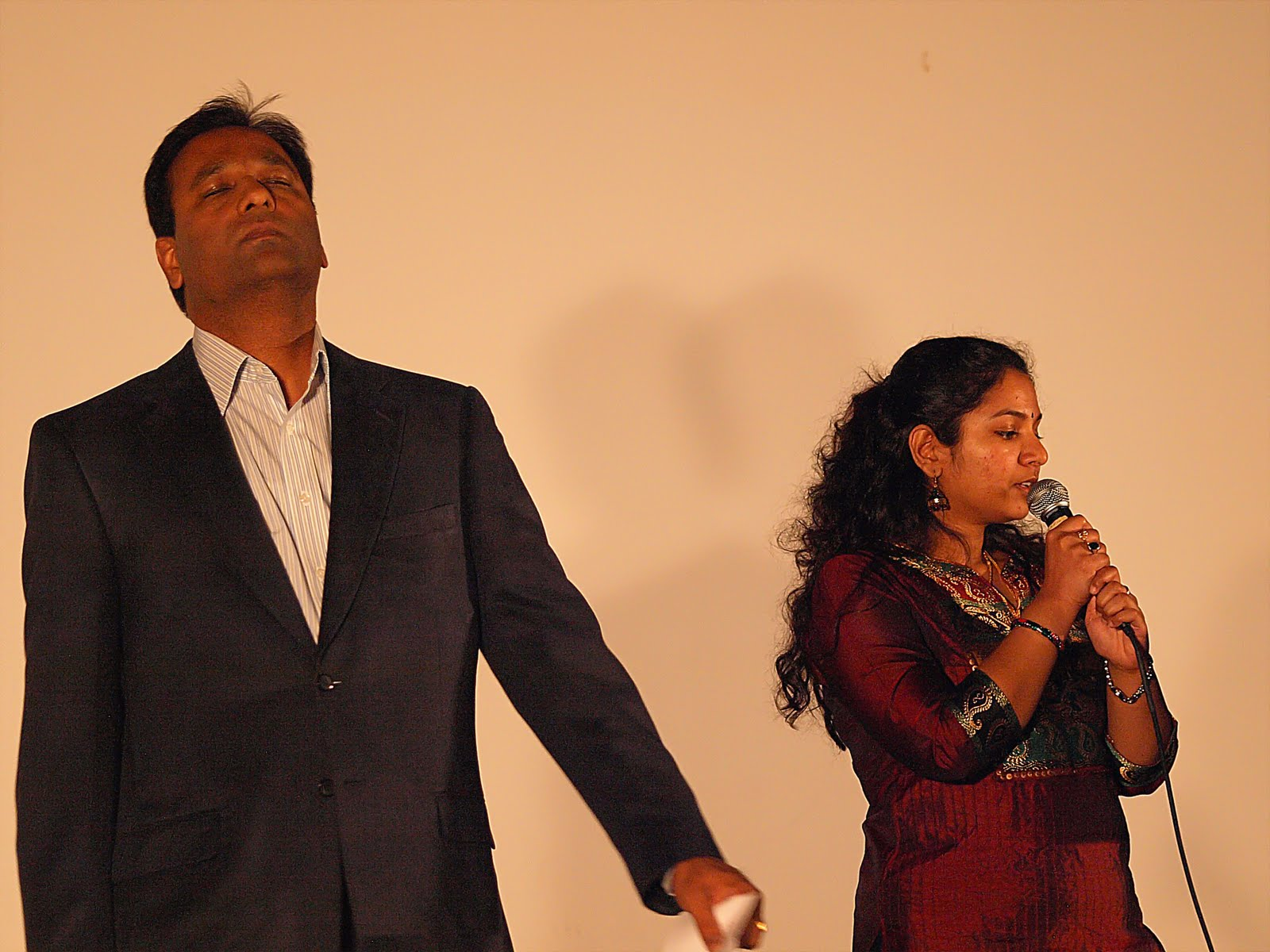 A man in a suit and a woman singing together