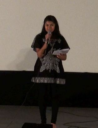 A woman singing, reading from sheet music