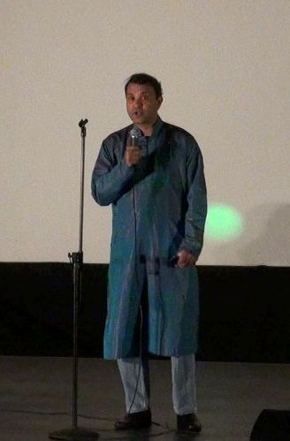 A man in a teal shirt, singing