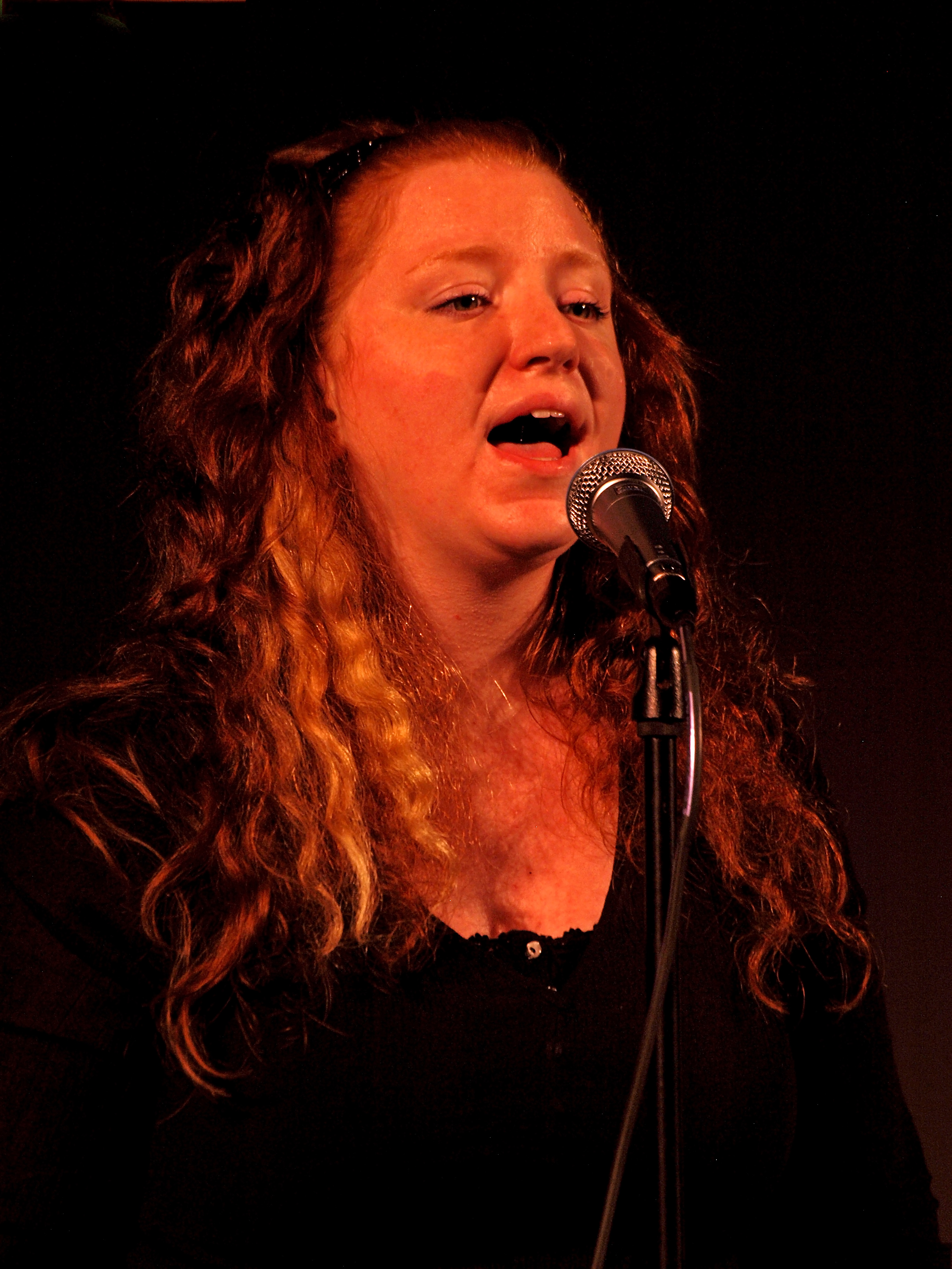 A woman singing with long wavy hair