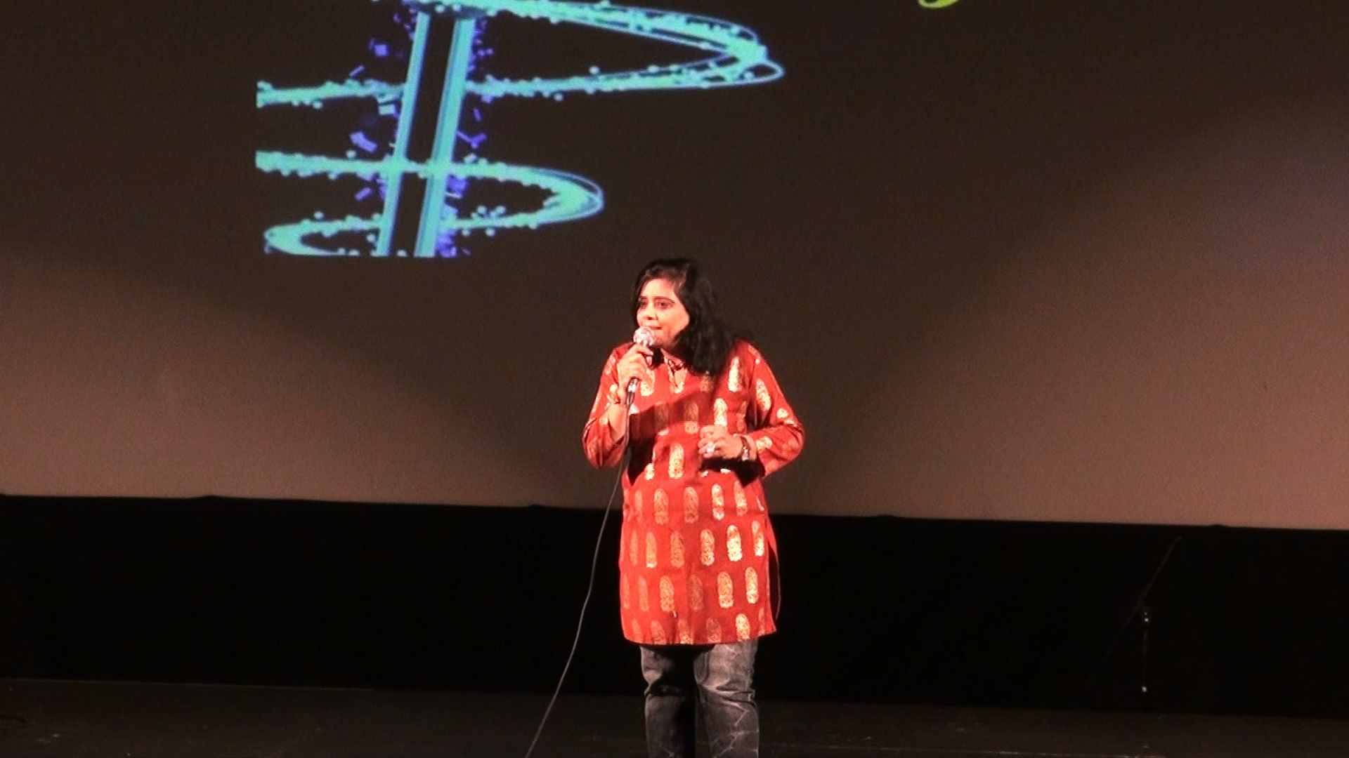 A woman in an orange outfit singing