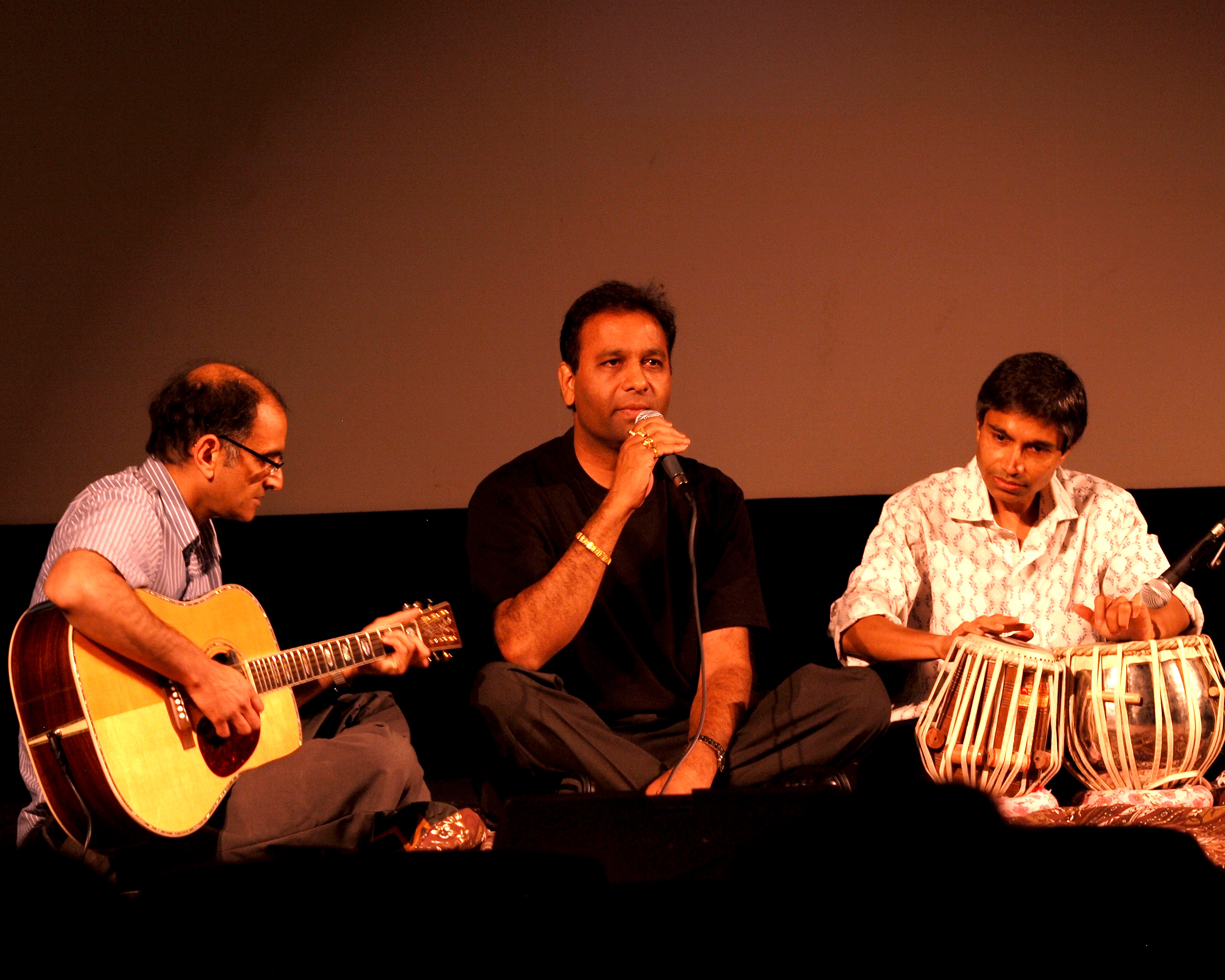 Two guitarists and a tabla player performing together