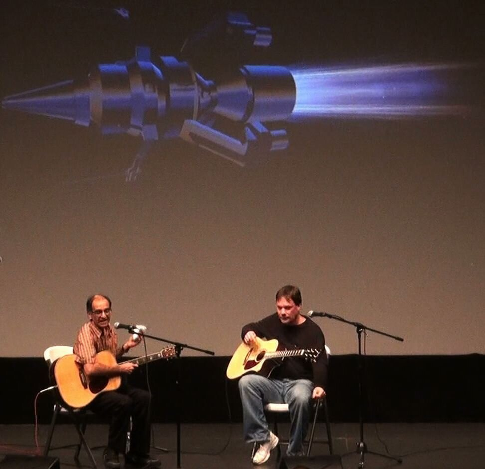 Two men playing acoustic guitars together