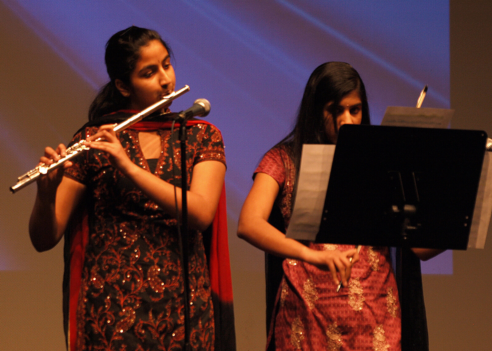 Two young women playing flute together