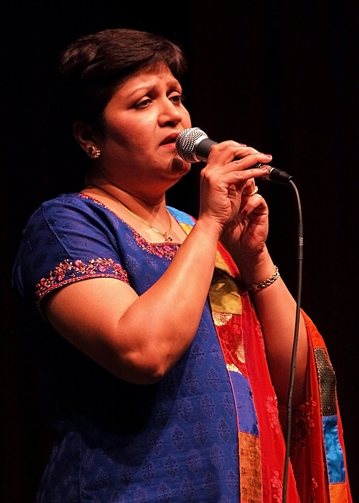A woman in a blue outfit singing