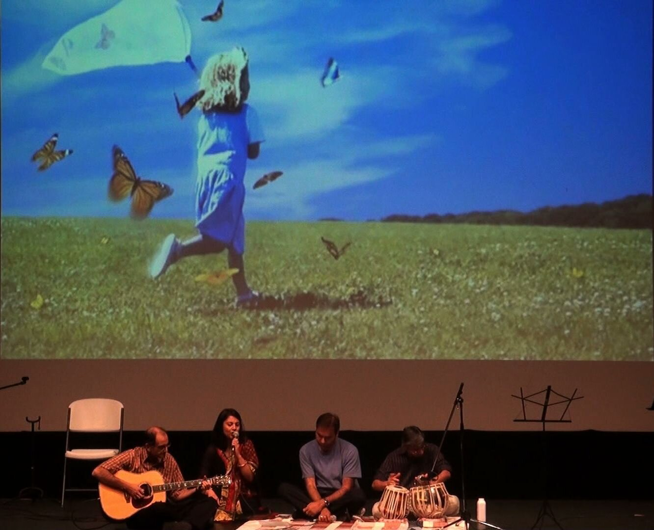 A performer singing in front of a projected screen