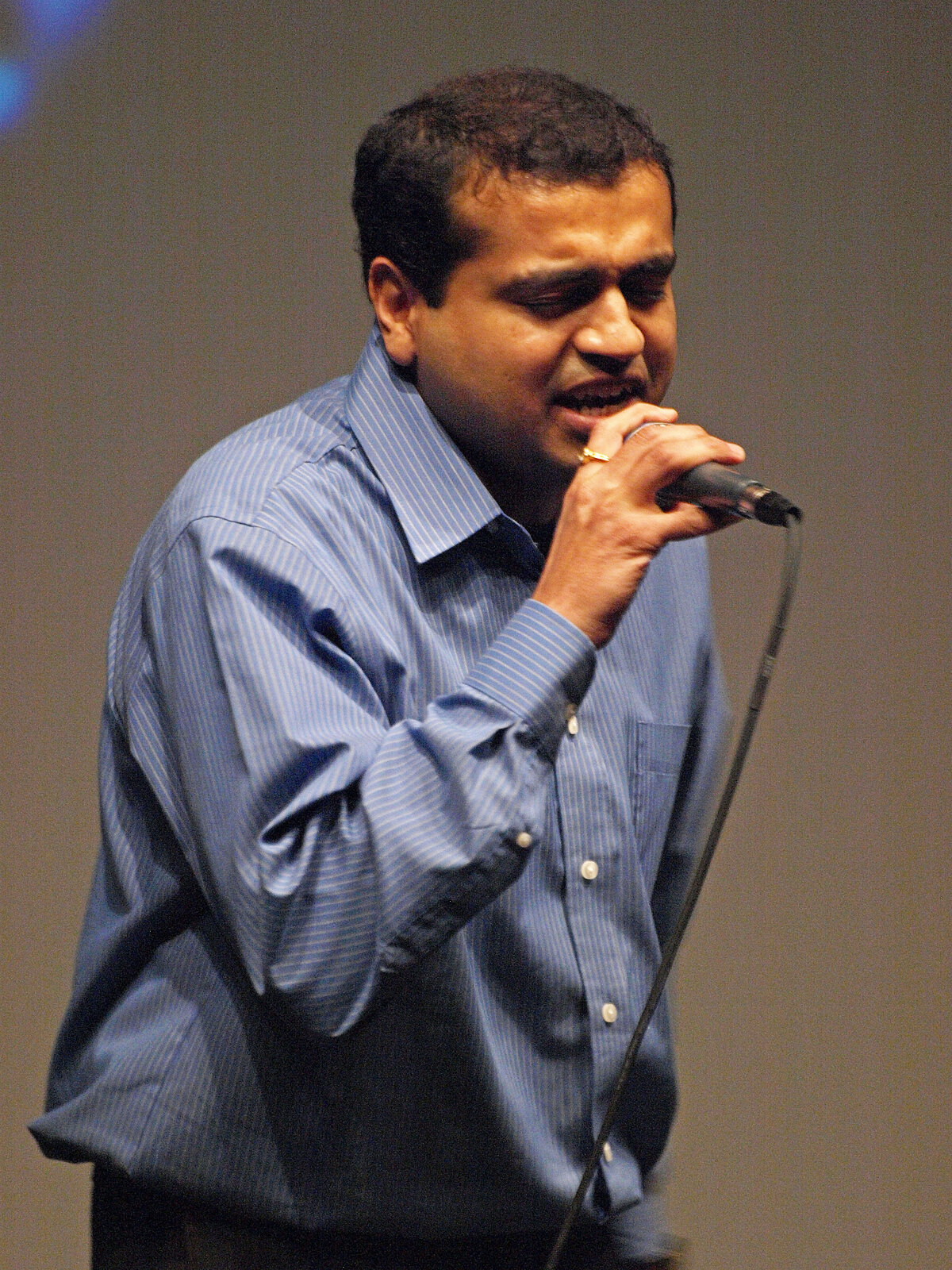 A man in a blue shirt singing