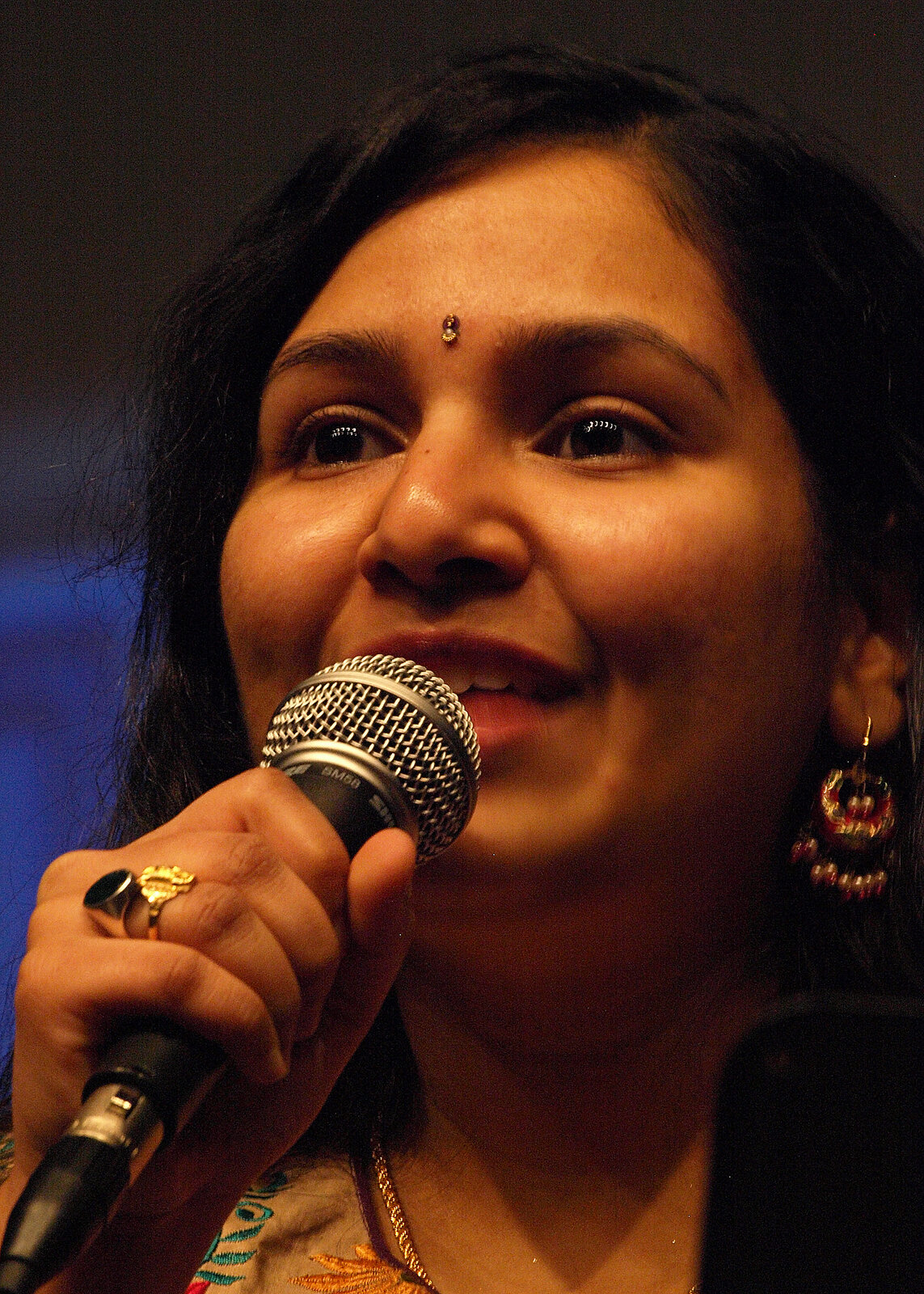 A woman in a floral outfit singing