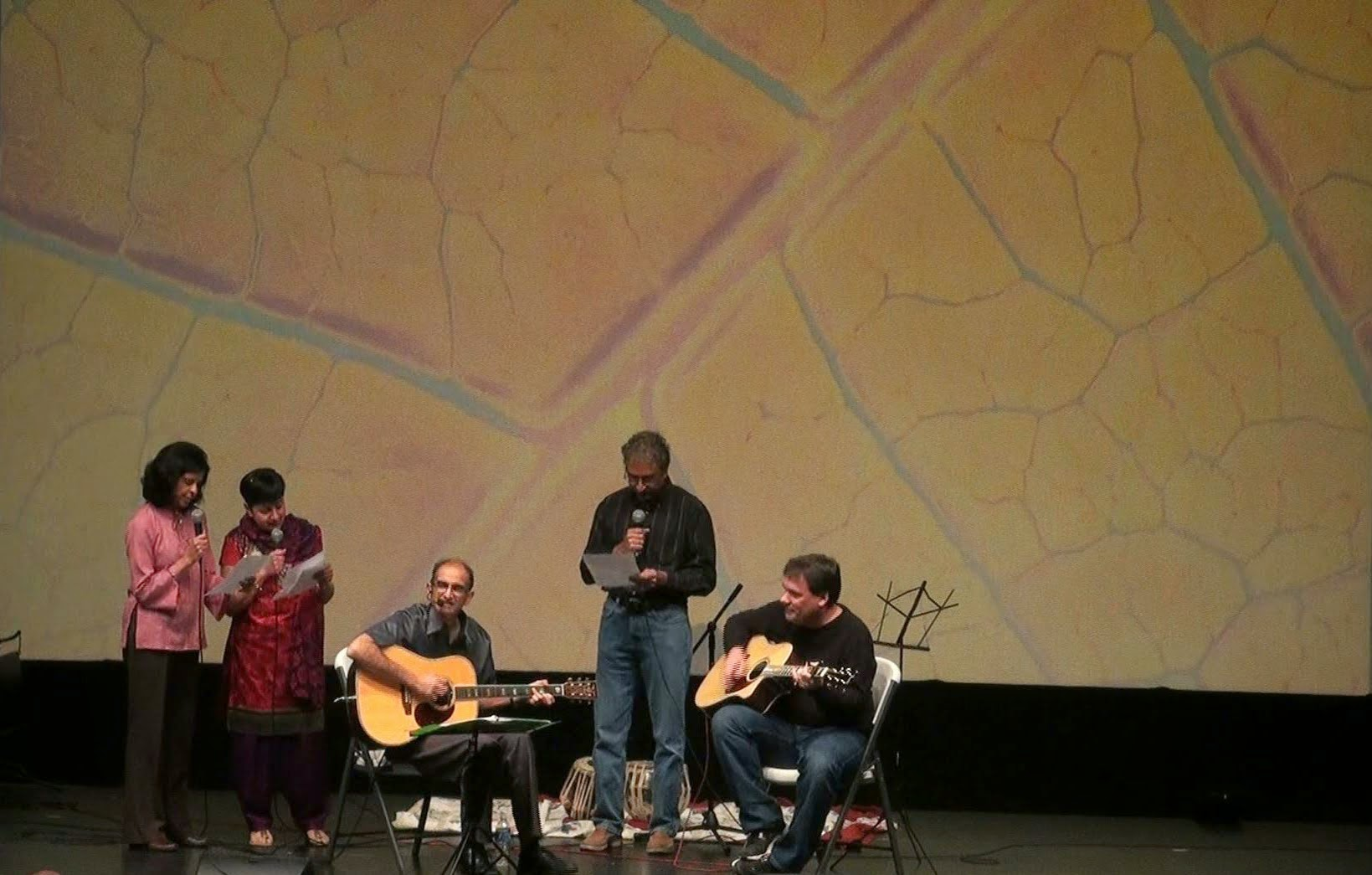 Three men performing together with acoustic guitars
