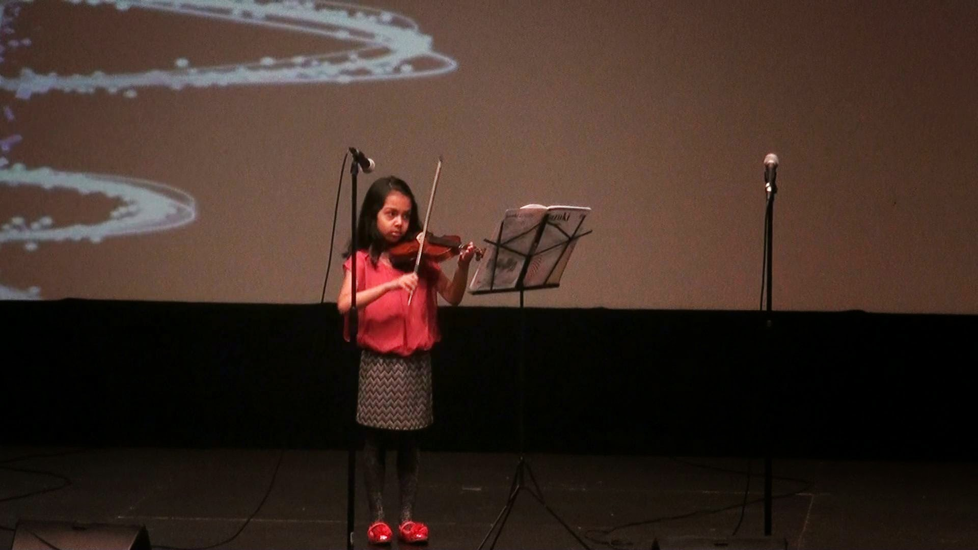 A young girl playing violin