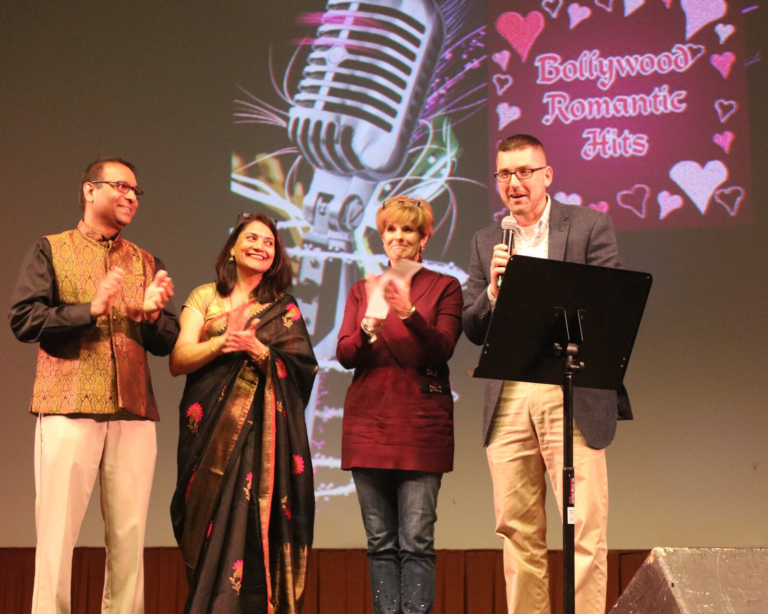 Four people on stage together during a presentation