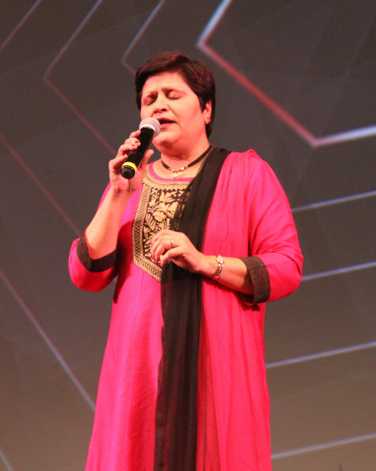 A woman in a pink and red outfit singing