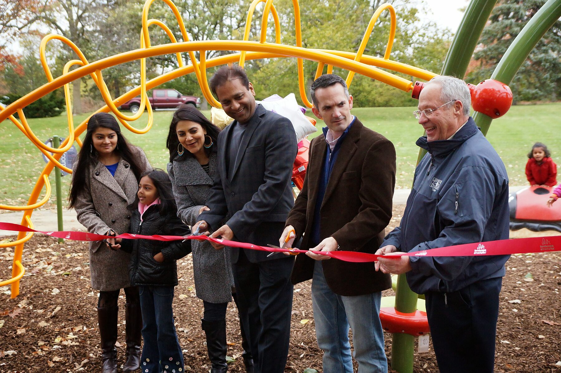 Township trustees and the Garg family cutting the ribbon at the Butterfly Meadow dedication