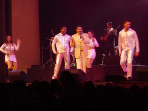 The full cast and band together on stage.